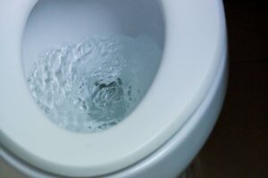 A toilet bowl with swirling water as it is being flushed