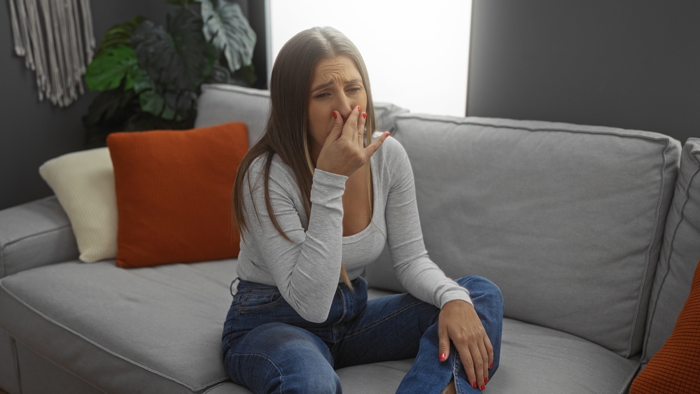 woman covers nose because she smells something stinky