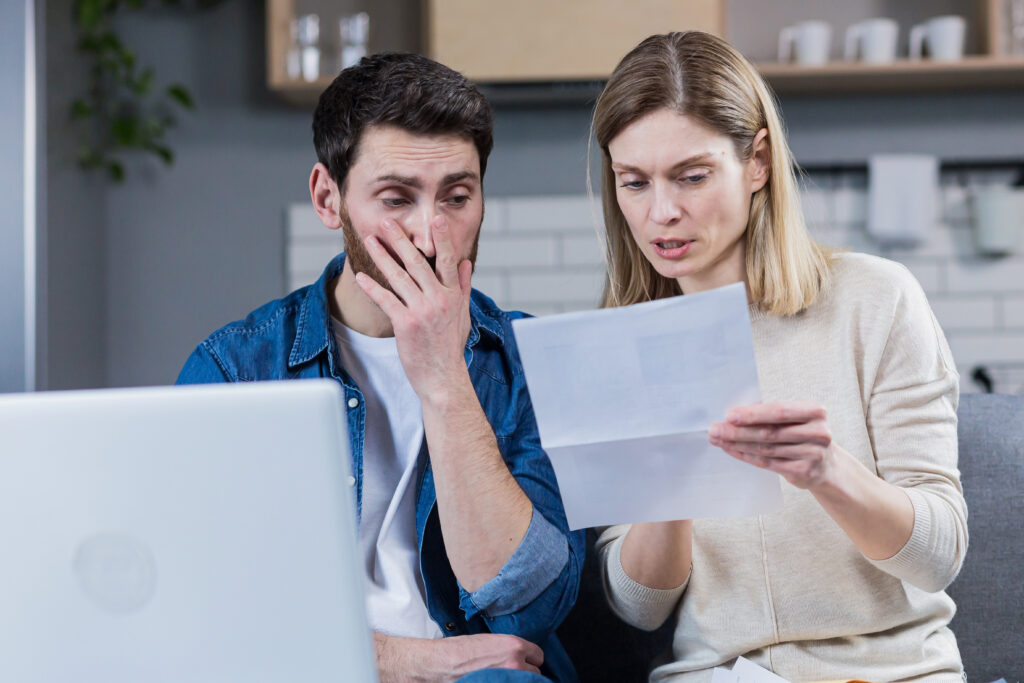 a worried couple looking at their documents